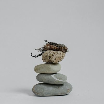 A balanced stack of smooth stones on a neutral background.