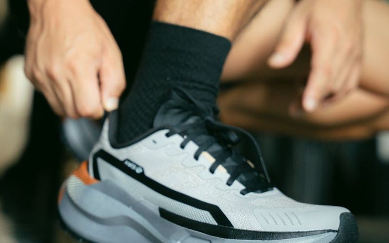 Close-up of athletic shoes on a wooden floor, ready for exercise.